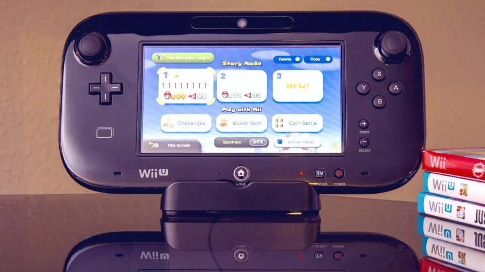 Consola de juegos Wii U en una mesa brillante con juegos de Wii U al lado