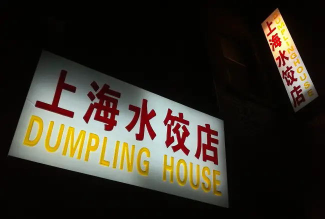 Una foto nocturna del letrero iluminado del restaurante Dumpling House tomada con un iPhone 4.